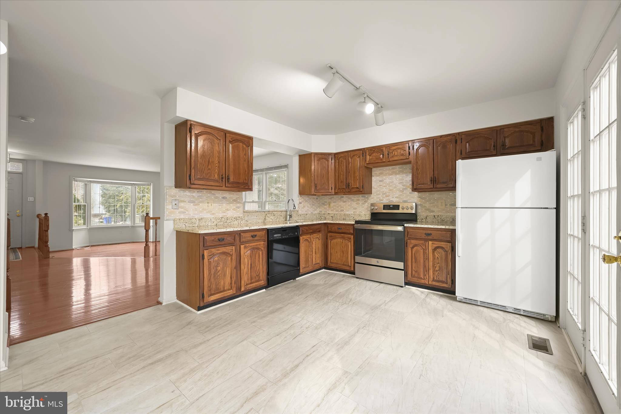 4750 Rams Horn Row Ellicott City, MD 21042 - Photo 18 of 54 a kitchen with granite countertop a refrigerator and a stove top oven