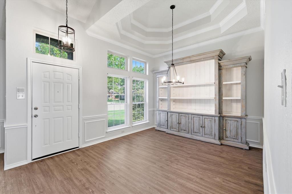 318 Lodge Road Coppell, TX 75019 - Photo 5 of 35 Soaring ceilings, oversized windows and a striking built-in display cabinet give this dining space impressive character and charm.