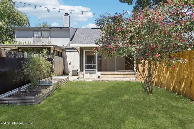 a view of a livingroom with wooden floor a ceiling fan and staircase