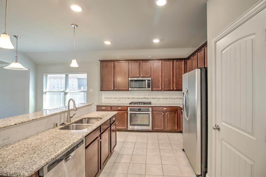 1925 Alton Way Aubrey, TX 76227 - Photo 8 of 32 a kitchen with stainless steel appliances granite countertop a sink stove and refrigerator