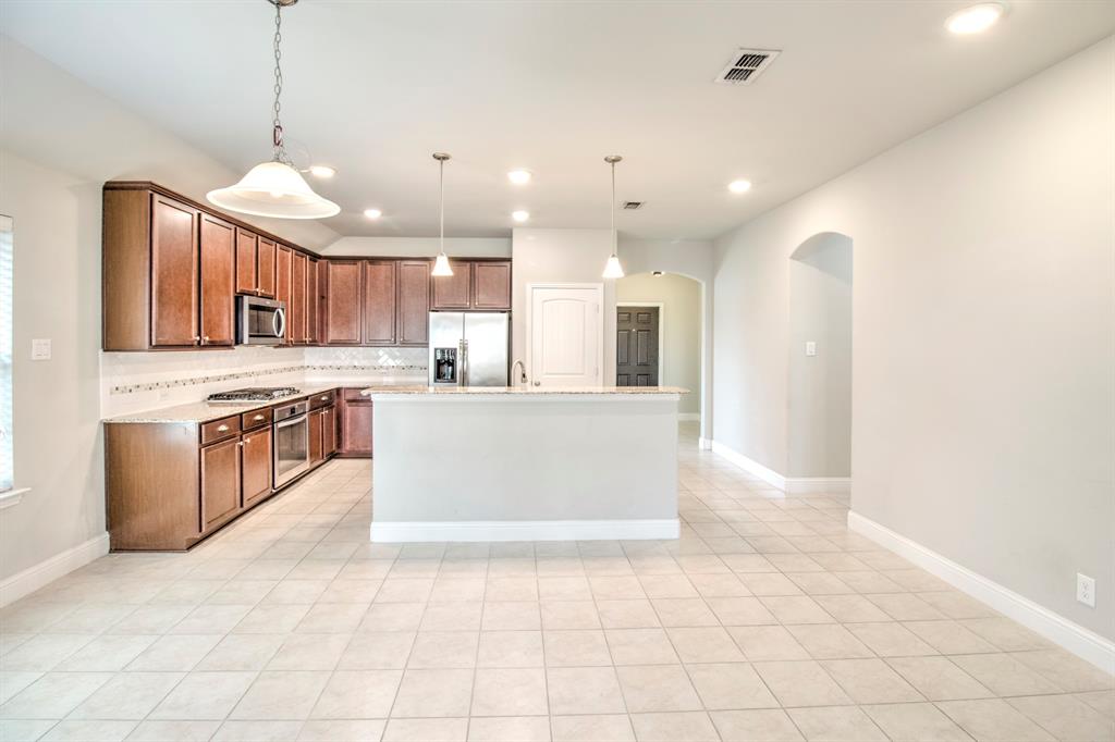 1925 Alton Way Aubrey, TX 76227 - Photo 10 of 32 a large kitchen with granite countertop a large counter top a sink stainless steel appliances and cabinets