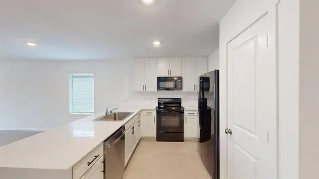 a kitchen with stainless steel appliances granite countertop a refrigerator and a sink