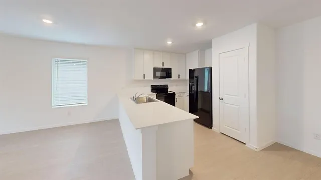 a kitchen with refrigerator and windows