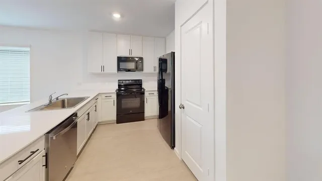 a kitchen with stainless steel appliances granite countertop a refrigerator and a sink