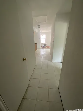 a view of hallway with bathroom and a sink
