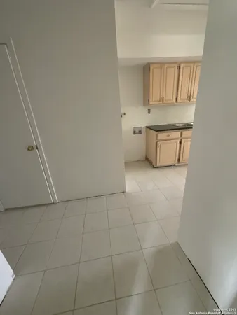 a kitchen with white cabinets and a refrigerator