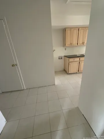a kitchen with white cabinets and a refrigerator