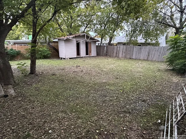 a white house that has tree in front of it