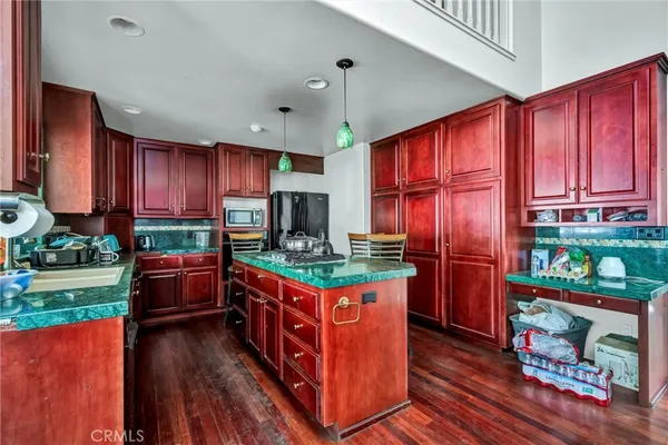 a kitchen with stainless steel appliances granite countertop a stove top oven a refrigerator and a dining table