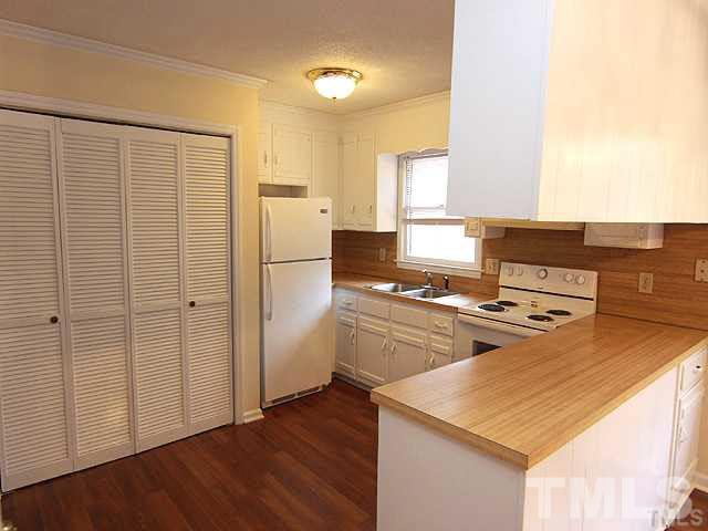 4400 Stonewall Drive Raleigh, NC 27604 - Photo 3 of 8 a kitchen with wooden cabinets and white appliances