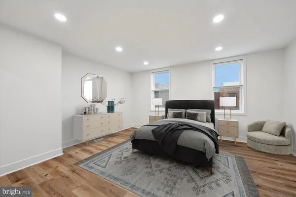 a large bedroom with a bed and wooden floor