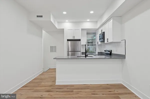 a kitchen with stainless steel appliances granite countertop a sink stove and cabinets