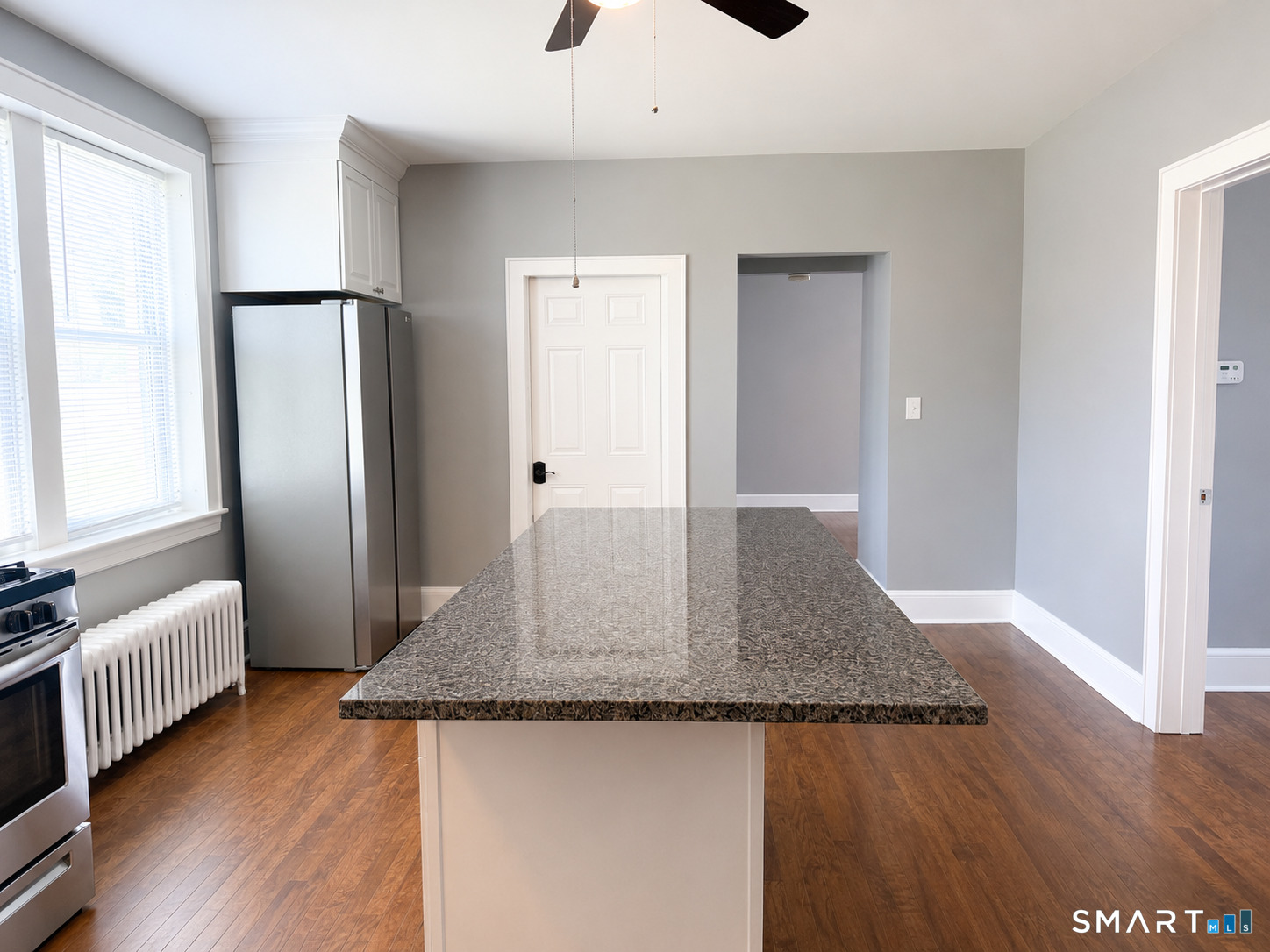 793 Milford Point Road, Unit 1 Milford, CT 06460 - Photo 3 of 16 a kitchen with granite countertop a refrigerator and wooden floor