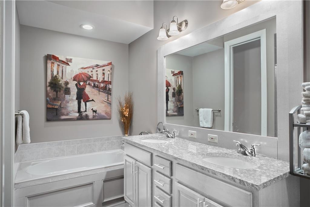 301 Fifth Avenue, Unit 511 Pittsburgh, PA 15222 - Photo 16 of 33 a bathroom with a granite countertop tub sink and mirror
