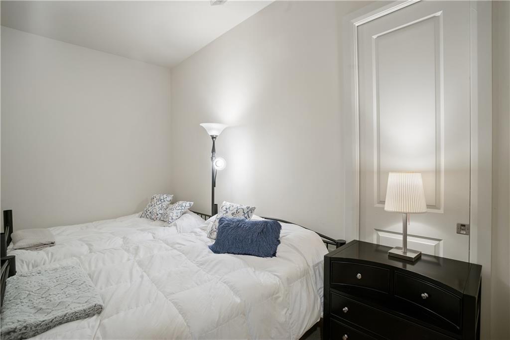 301 Fifth Avenue, Unit 511 Pittsburgh, PA 15222 - Photo 20 of 33 a bedroom with a bed and a lamp