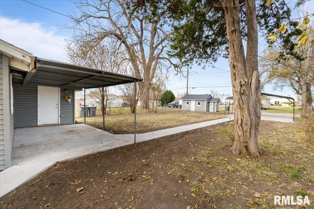 a view of a house with a large tree and wooden fence