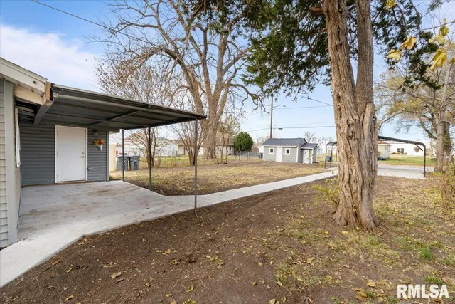 a view of a house with a large tree and a yard