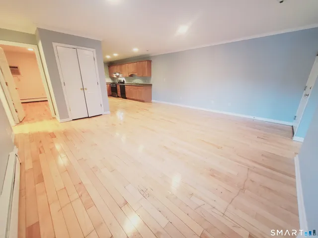 a view of empty room with wooden floor