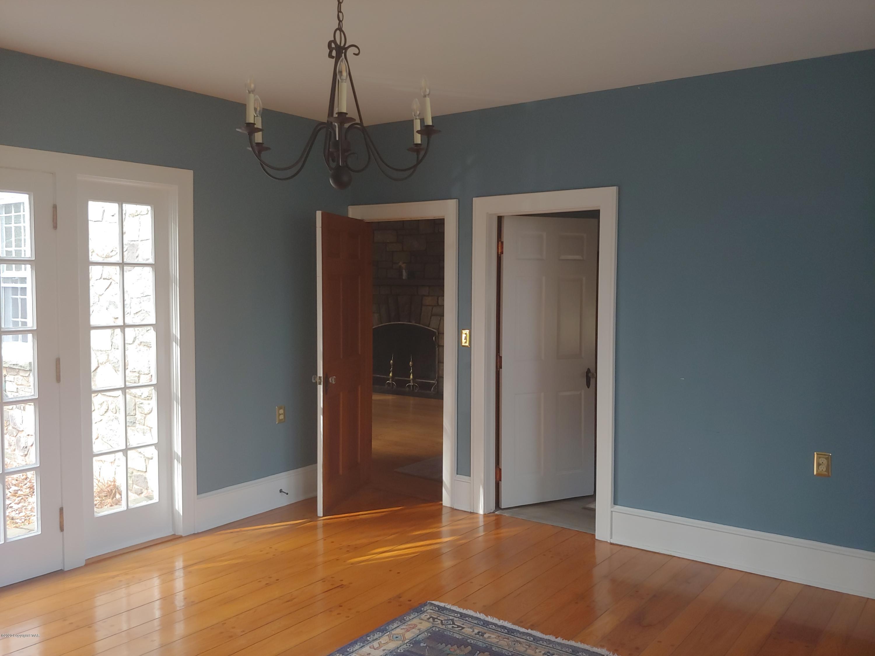 476 Laurel Pine Road Cresco, PA 18326 - Photo 13 of 45 an empty room with wooden floor chandelier and windows