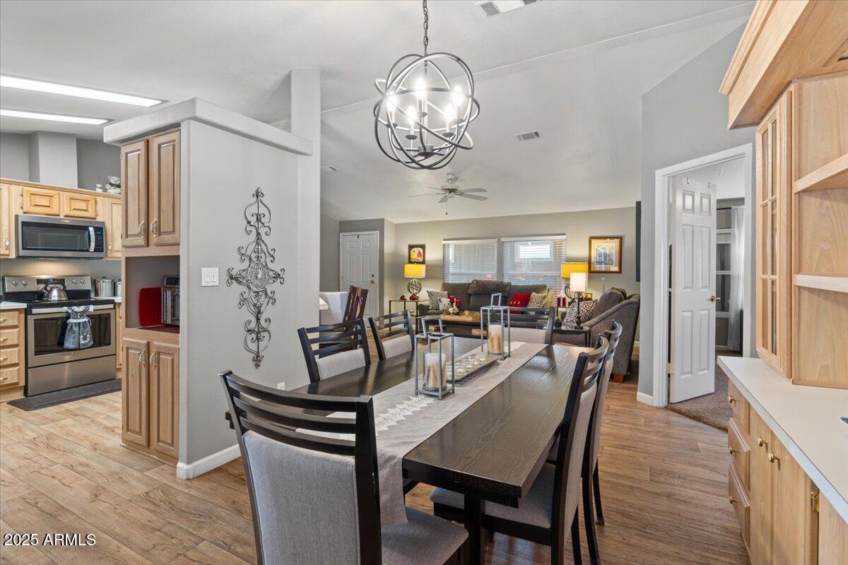 834 South Meridian Road, Unit 54 Apache Junction, AZ 85120 - Photo 16 of 56 a view of a dining room with furniture a chandelier and wooden floor