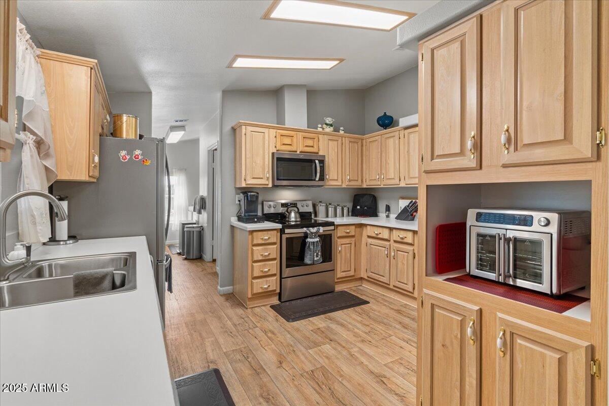 834 South Meridian Road, Unit 54 Apache Junction, AZ 85120 - Photo 17 of 56 a kitchen with stainless steel appliances granite countertop a stove a sink and a microwave