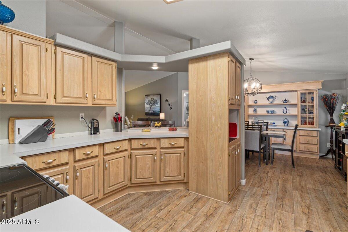 834 South Meridian Road, Unit 54 Apache Junction, AZ 85120 - Photo 18 of 56 a kitchen with granite countertop a refrigerator a sink dishwasher a dining table and chairs with wooden floor