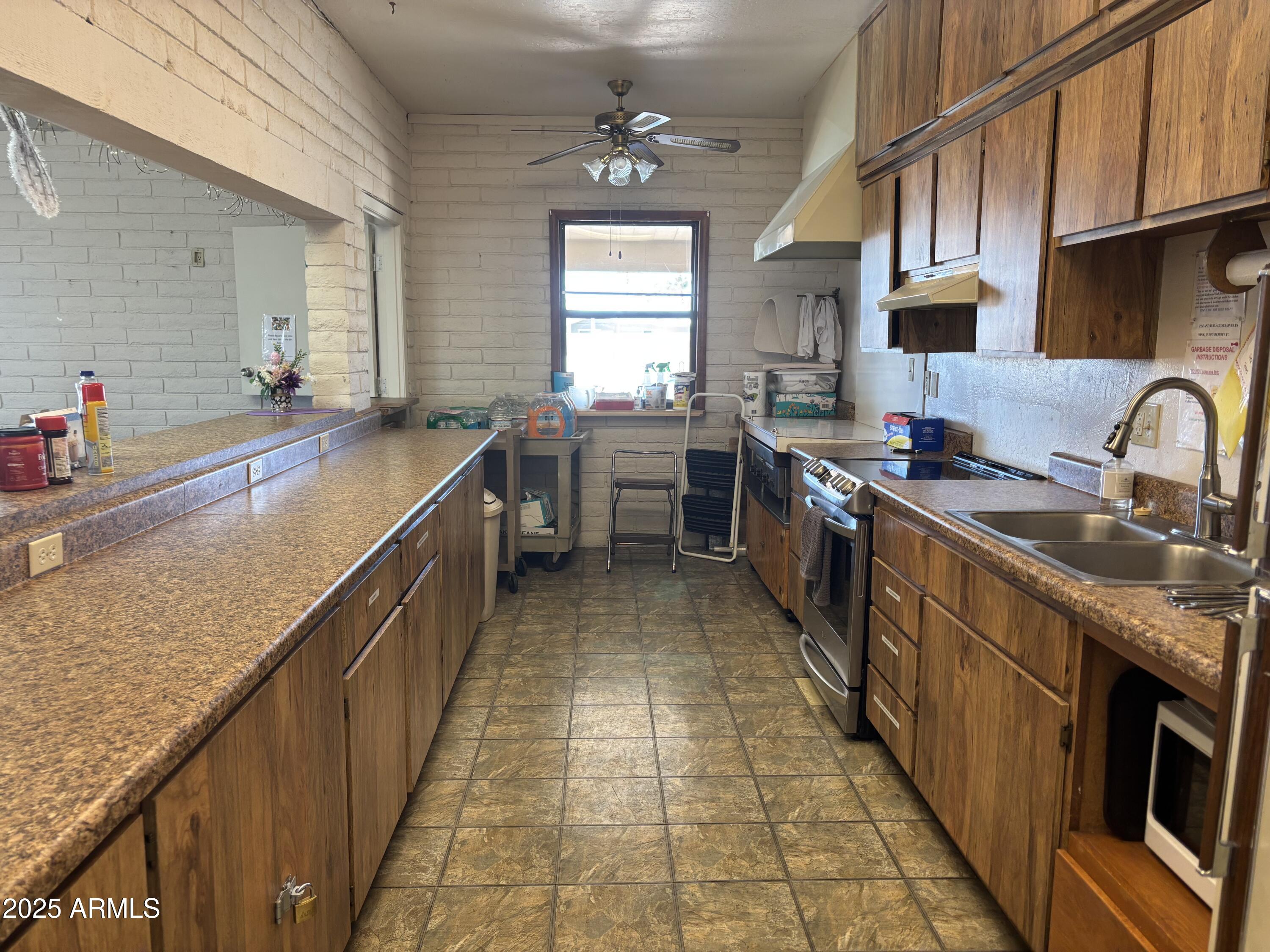 834 South Meridian Road, Unit 54 Apache Junction, AZ 85120 - Photo 48 of 56 a kitchen with stainless steel appliances granite countertop a sink counter space a stove and a window