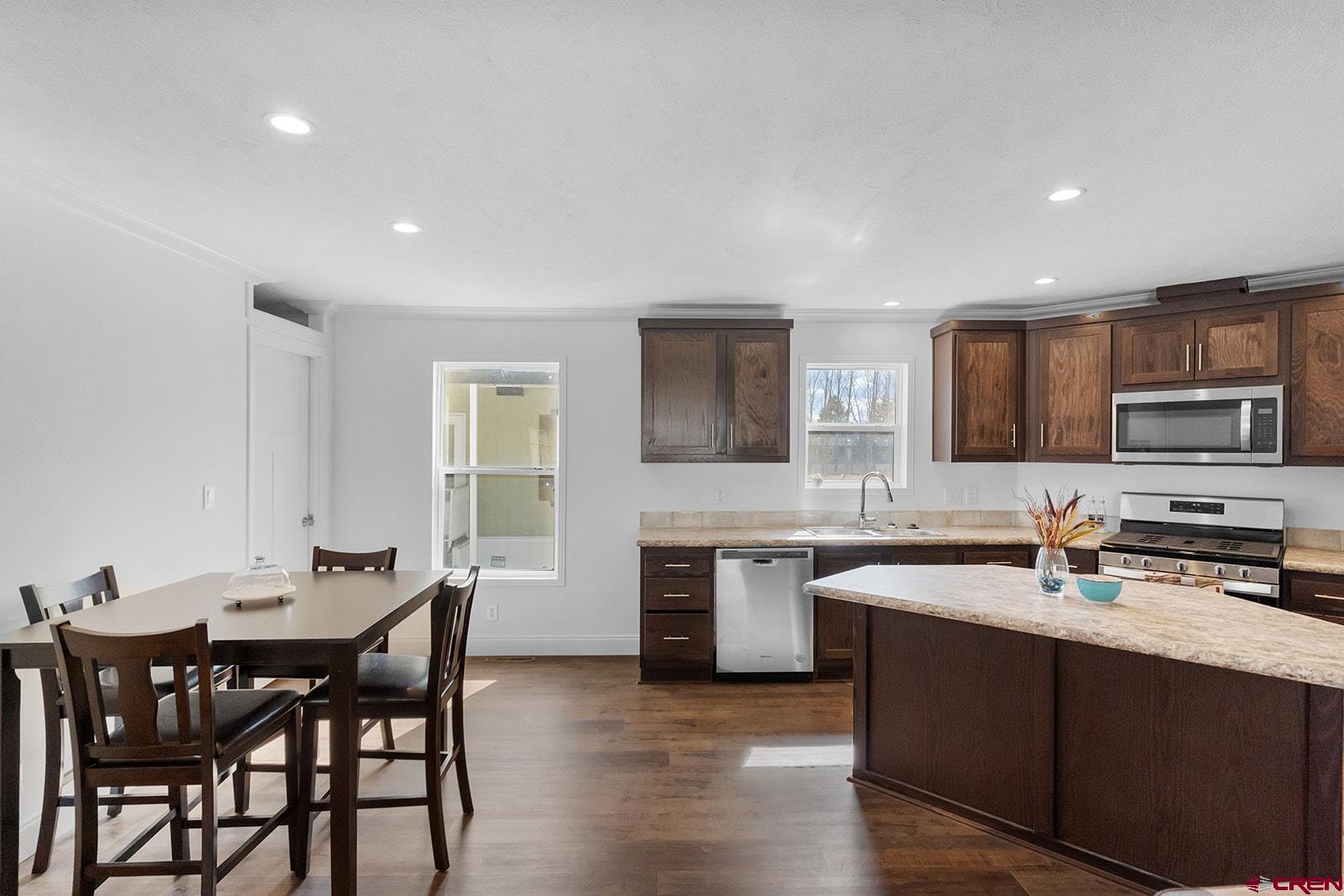 901 6530 Road, Unit 1504 Montrose, CO 81401 - Photo 10 of 25 a kitchen with stainless steel appliances granite countertop a sink a stove a table and chairs