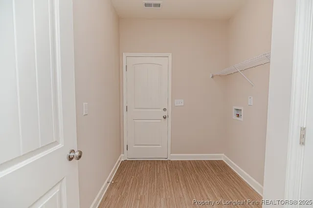 a view of a small space with wooden floor and closet