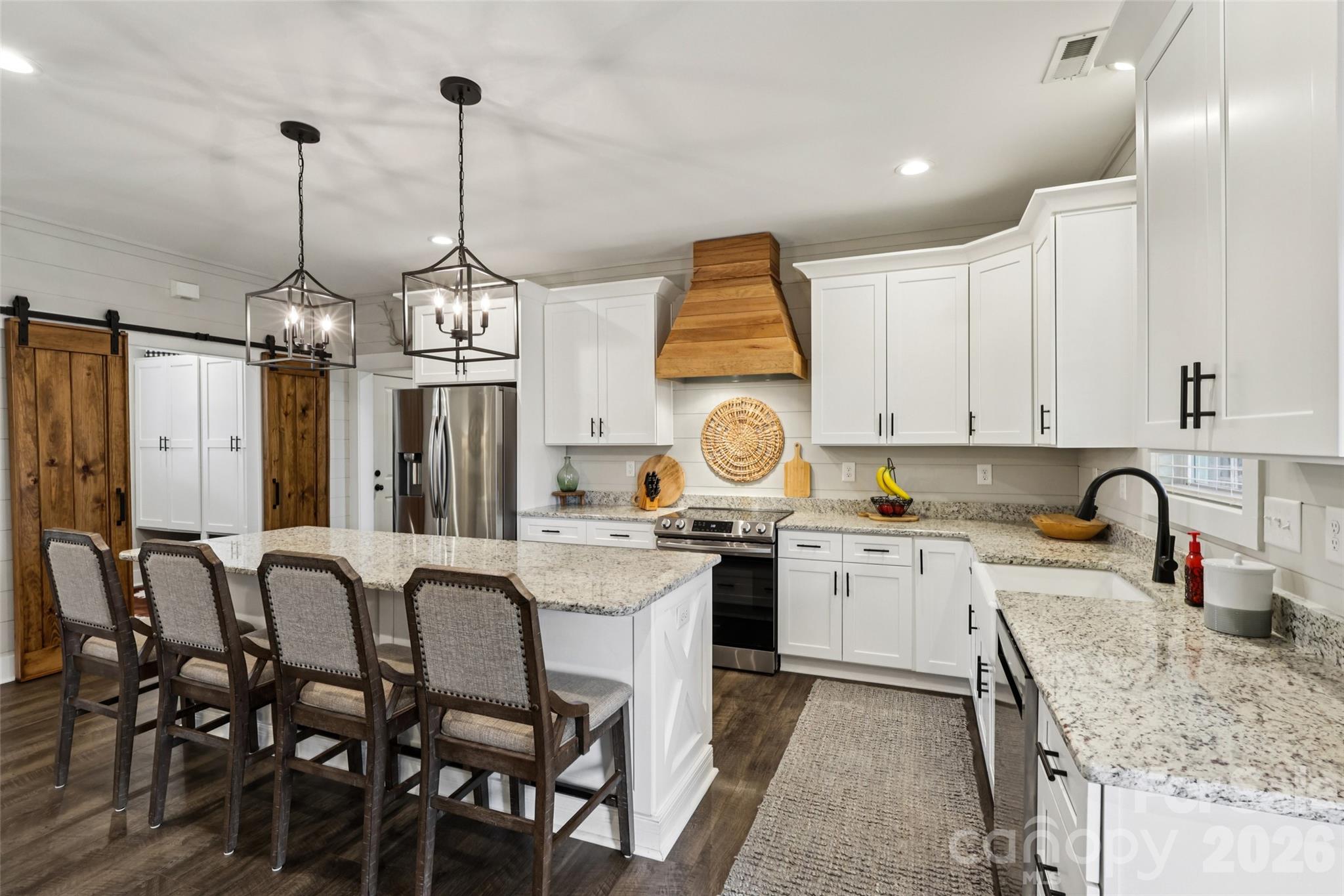 2807 Noritake Trail Albemarle, NC 28001 - Photo 14 of 45 a kitchen with stainless steel appliances granite countertop a stove top oven a sink a dining table and chairs with wooden floor