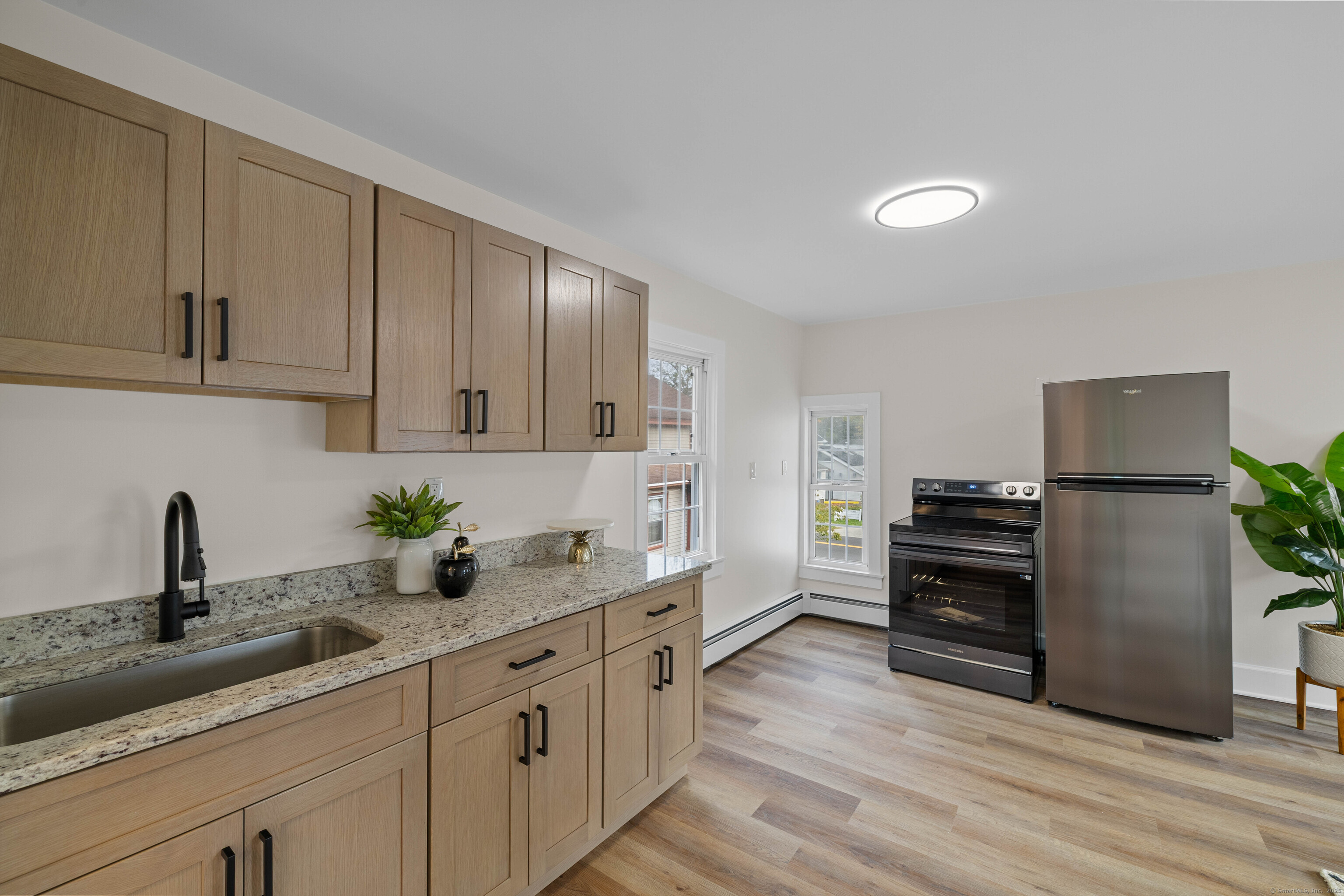 82 State Street Guilford, CT 06437 - Photo 22 of 40 a kitchen with granite countertop a refrigerator and a sink
