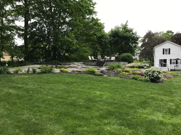 a front view of house with yard and trees in the background