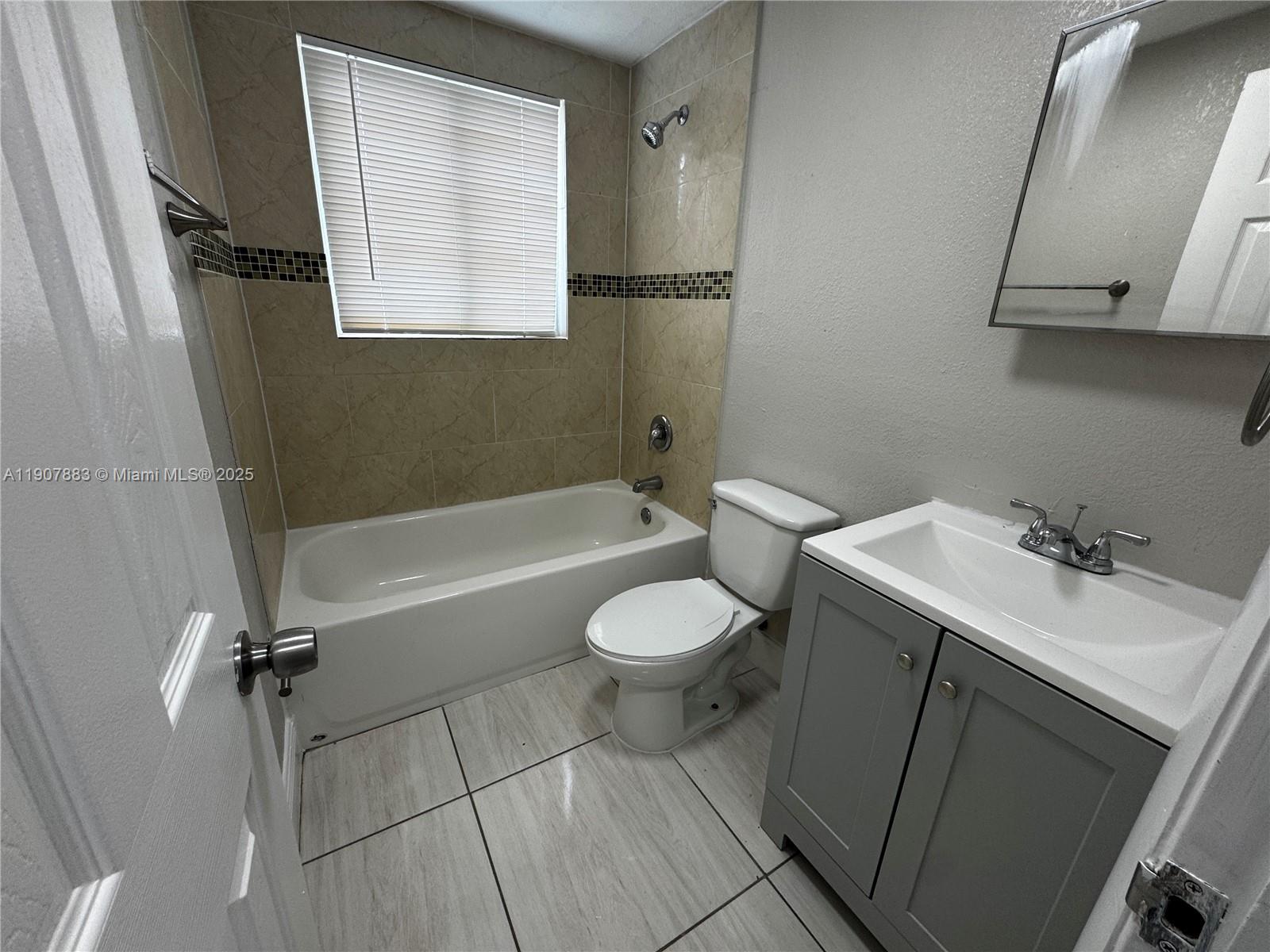 1940 Washington Avenue, Unit 15 Opa-Locka, FL 33054 - Photo 4 of 17 a bathroom with a sink a toilet and a bathtub