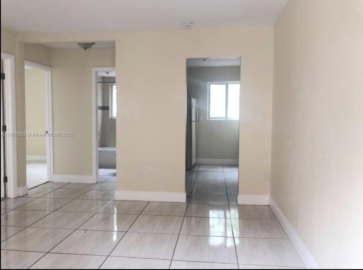 1940 Washington Avenue, Unit 15 Opa-Locka, FL 33054 - Photo 5 of 17 an empty room with a elevator and a mirror