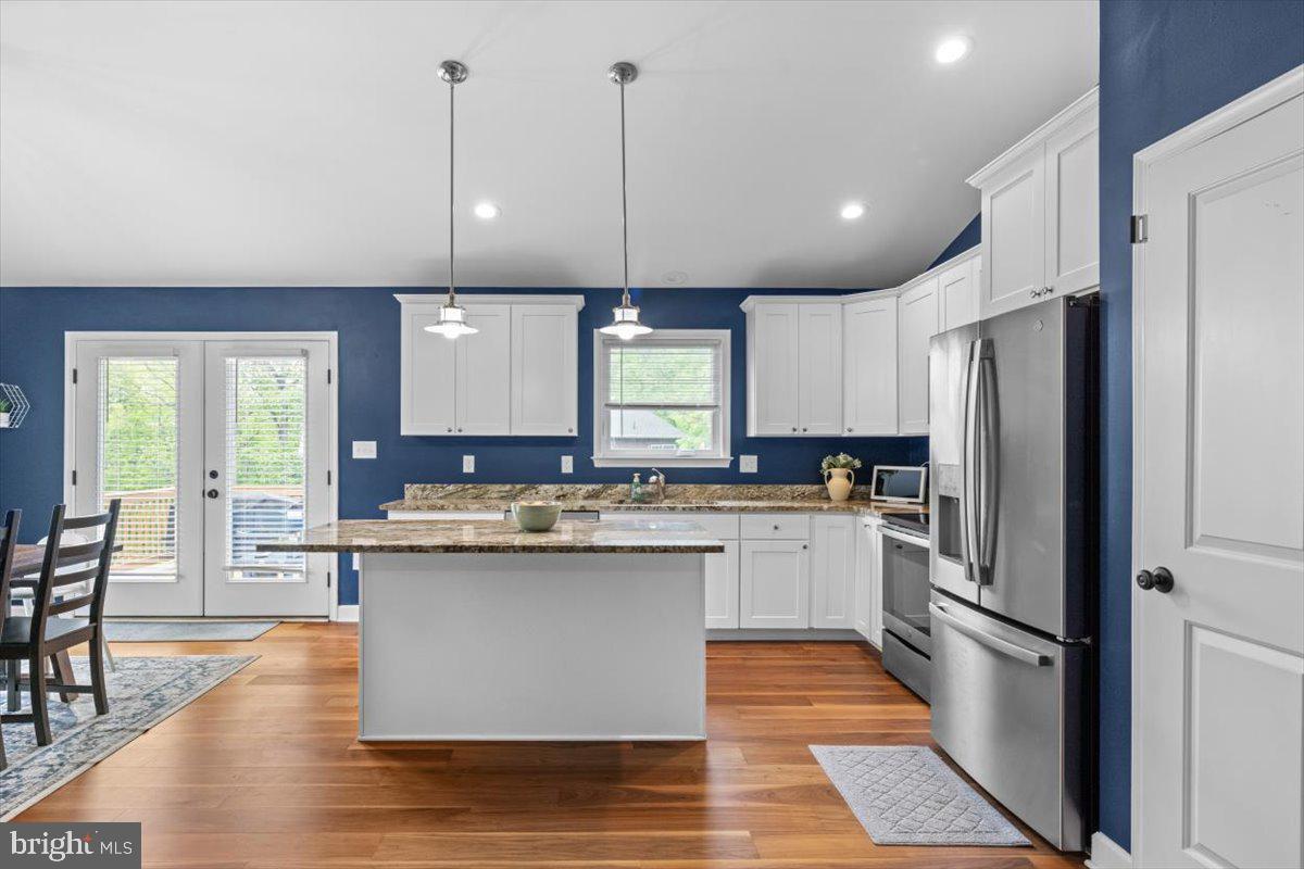 106 Split Rail Road Front Royal, VA 22630 - Photo 5 of 35 a kitchen with stainless steel appliances granite countertop a refrigerator a sink dishwasher a oven and a dining table with wooden floor