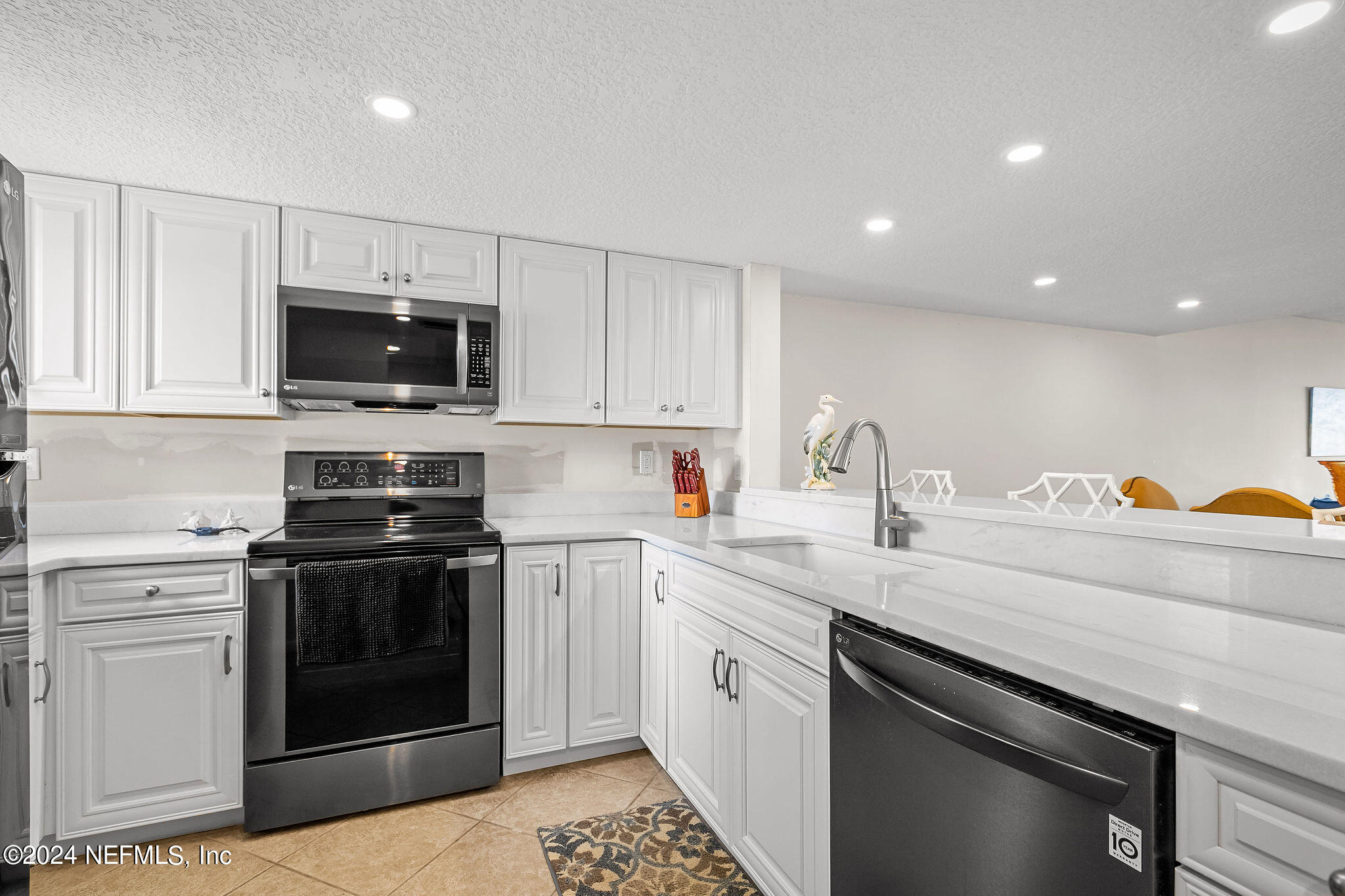 390 A1A Beach Boulevard, Unit 50 St. Augustine, FL 32080 - Photo 6 of 20 a kitchen with a sink stove and microwave