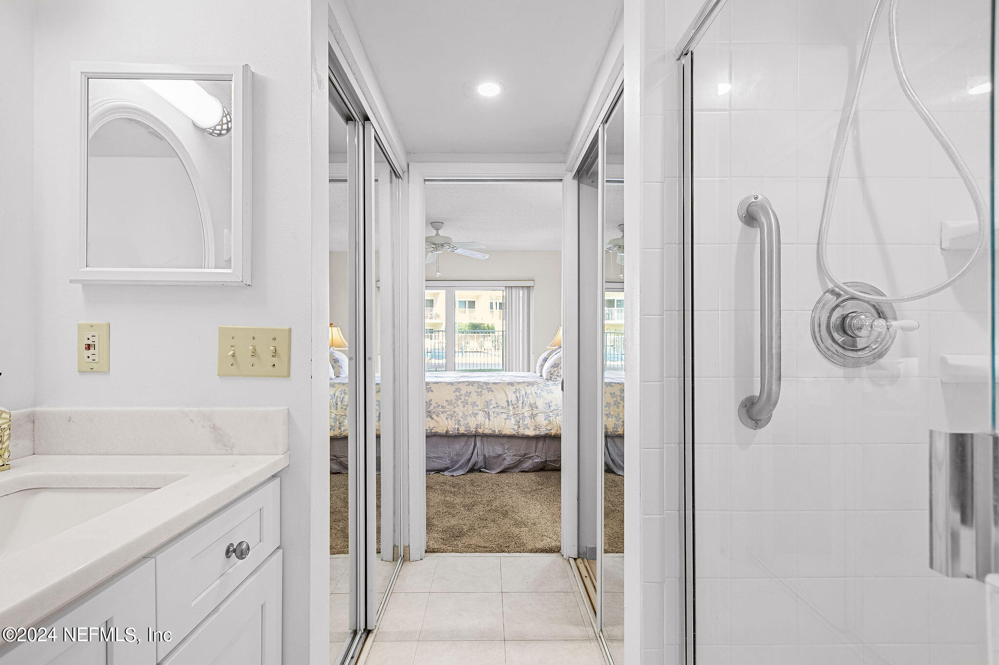 390 A1A Beach Boulevard, Unit 50 St. Augustine, FL 32080 - Photo 10 of 20 a bathroom with a granite countertop shower mirror and a sink
