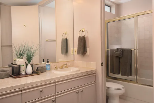 a bathroom with a sink a toilet and shower