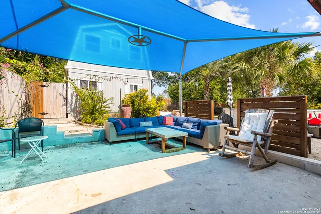a view of a patio with table and chairs under an umbrella