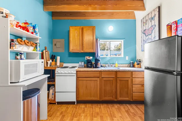 a kitchen with a refrigerator wooden floor and a sink