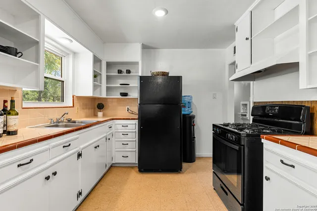 a kitchen with stainless steel appliances a refrigerator sink and cabinets