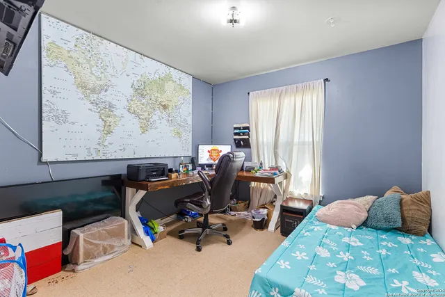 a bedroom with furniture and a large window