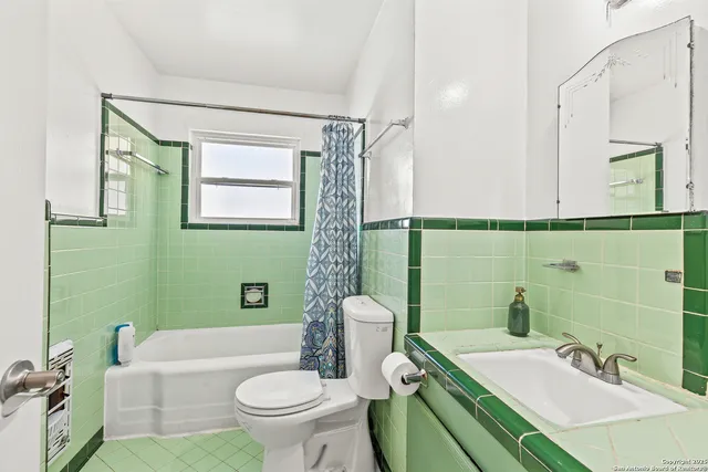 a bathroom with a sink a toilet a mirror and shower