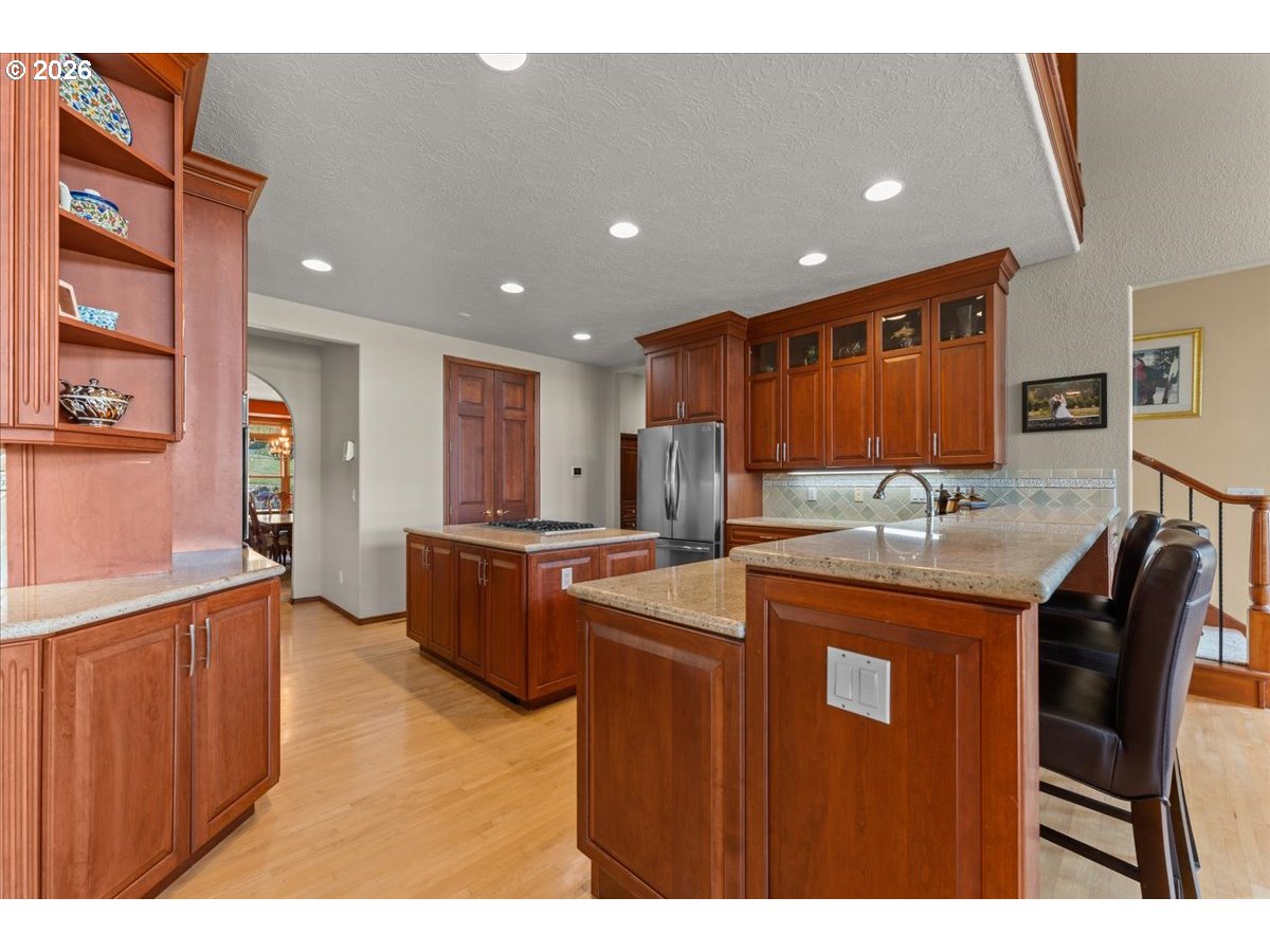 37123 Northeast Reed Road Corbett, OR 97019 - Photo 10 of 48 a kitchen with stainless steel appliances granite countertop a sink a stove a refrigerator a microwave oven with white cabinets and wooden floor