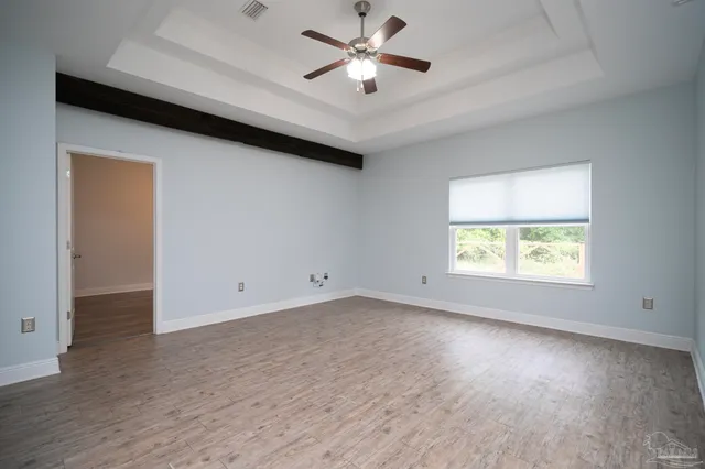 an empty room with a window and a ceiling fan