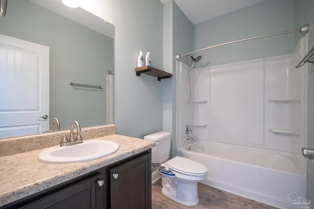 a bathroom with a granite countertop sink toilet and shower