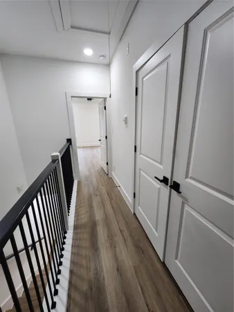 a view of a hallway with wooden floor and staircase