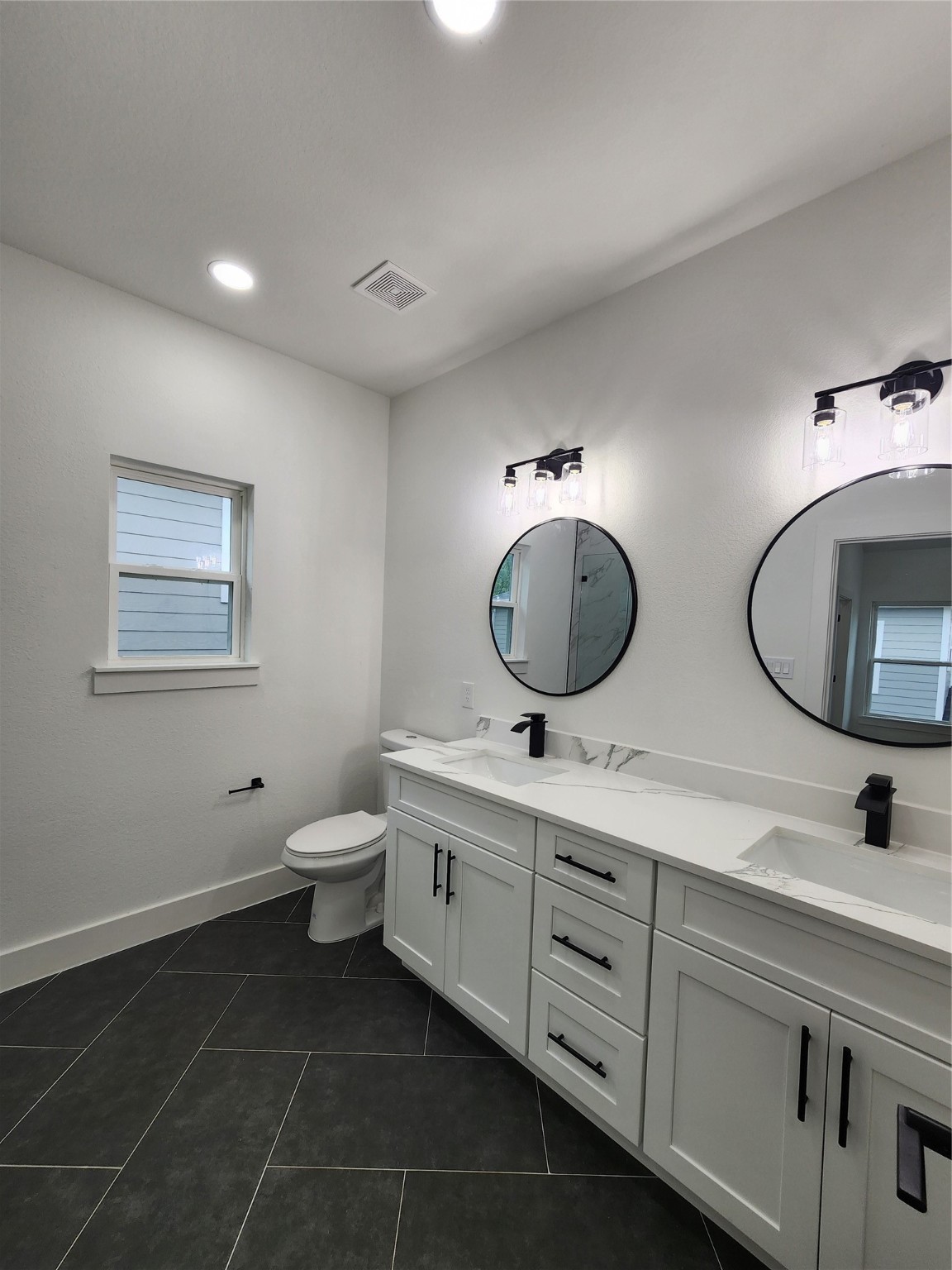 650 Everett Street, Unit B Conroe, TX 77301 - Photo 12 of 20 a bathroom with a double vanity sink mirror and toilet