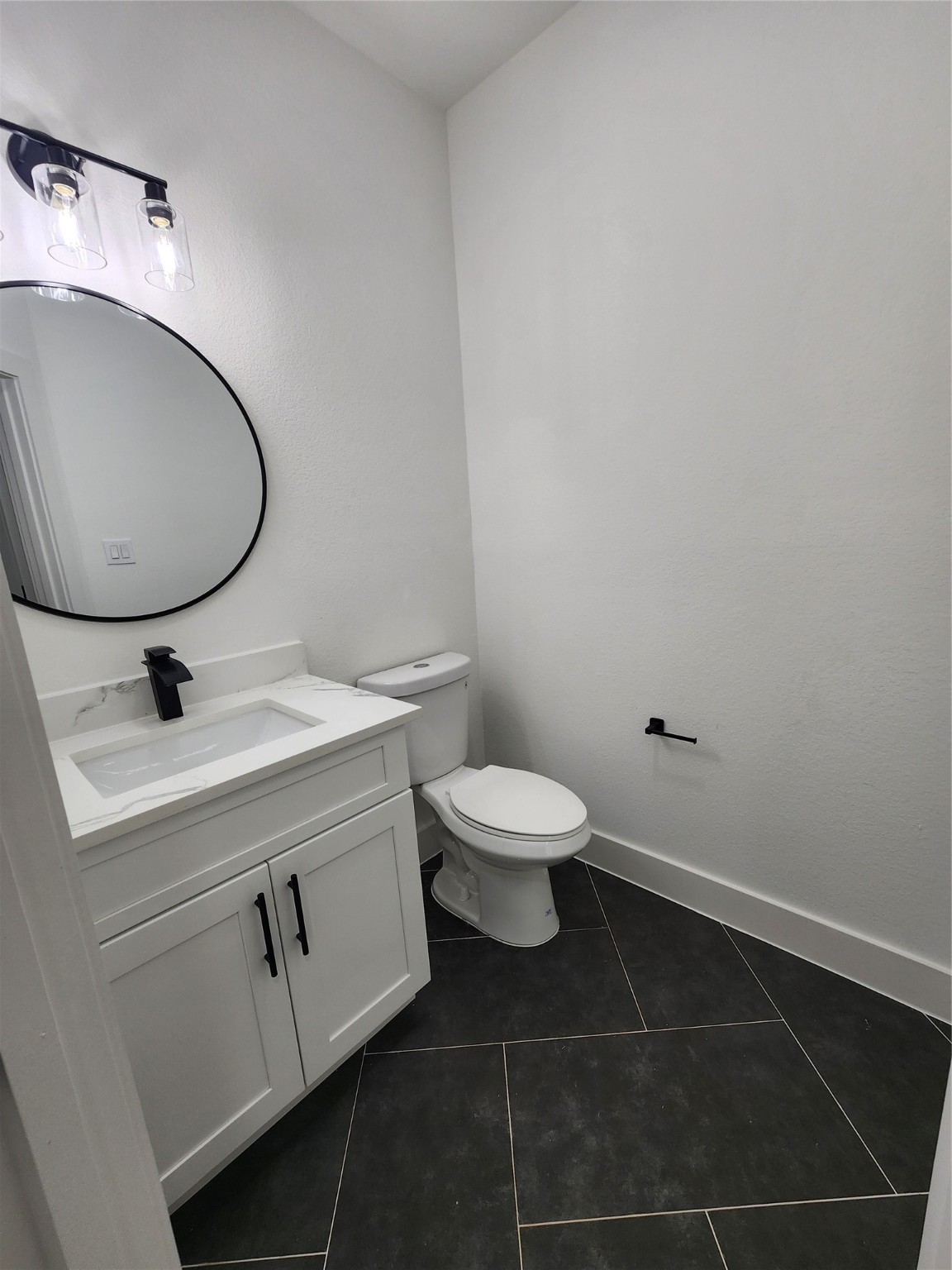 650 Everett Street, Unit B Conroe, TX 77301 - Photo 18 of 20 a bathroom with a toilet sink and mirror