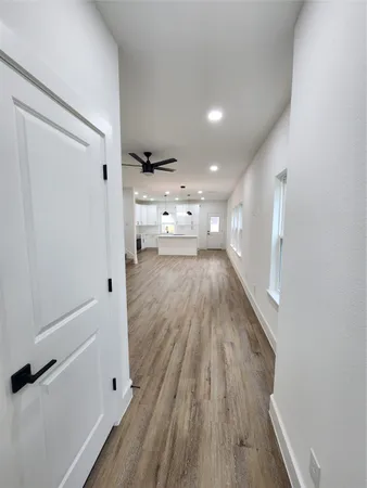 a view of a hallway with wooden floor and staircase